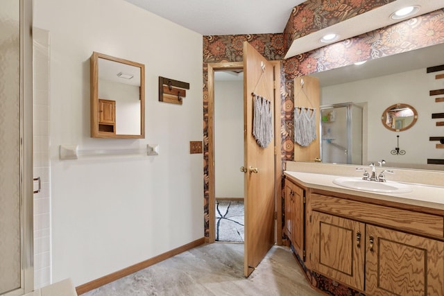 bathroom with baseboards, vanity, and a stall shower