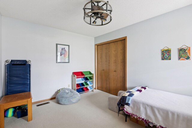 bedroom with a closet, carpet, visible vents, and baseboards
