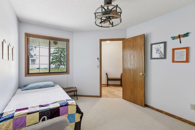 bedroom with baseboards, carpet flooring, and a textured ceiling