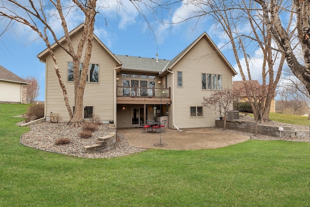 rear view of property featuring a patio, a lawn, central air condition unit, a wooden deck, and a shingled roof
