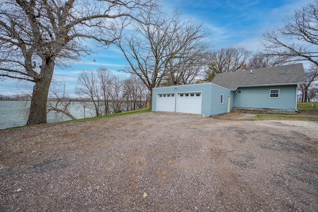 garage featuring a water view and dirt driveway