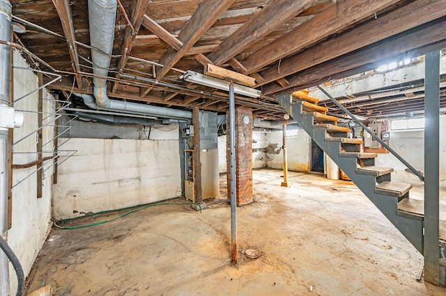 unfinished basement with stairway, heating unit, and electric panel