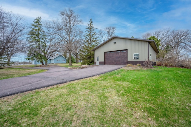 view of side of property featuring aphalt driveway and a lawn