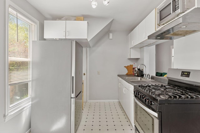2822 29th St, Minneapolis, MN 55406 - kitchen with stainless steel appliances, a sink, white cabinets, baseboards, and light flooring