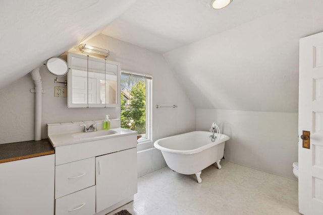 2822 29th St, Minneapolis, MN 55406 - full bathroom featuring vaulted ceiling, a freestanding bath, toilet, vanity, and tile patterned floors