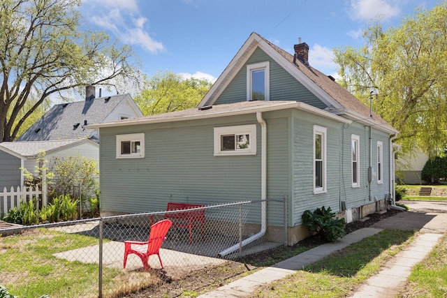 2822 29th St, Minneapolis, MN 55406 - view of side of property with fence, a patio area, and a chimney