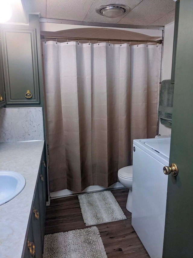 513 5th Ave, Ironton, MN 56455 - full bath featuring wood finished floors, vanity, toilet, washer / dryer, and a shower with shower curtain