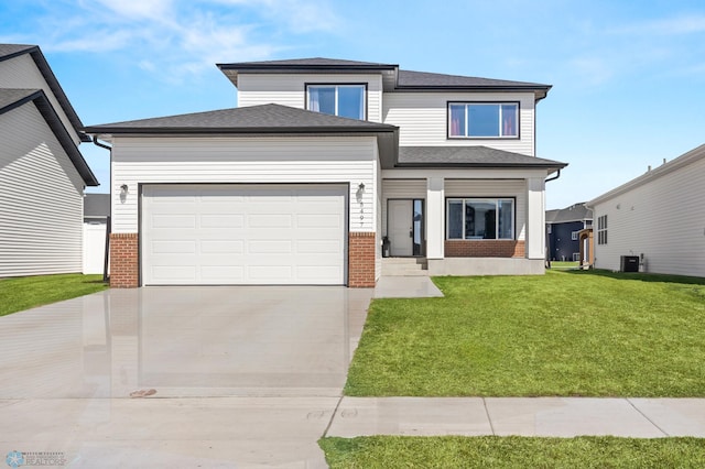 5497 11th St W, West Fargo, ND 58078 - prairie-style house featuring driveway, a shingled roof, a front yard, a garage, and brick siding