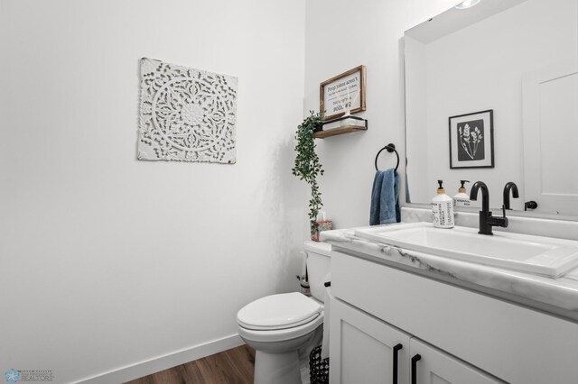 5497 11th St W, West Fargo, ND 58078 - half bathroom featuring baseboards, wood finished floors, toilet, and vanity