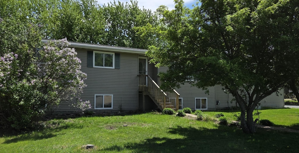 829 1st Ave SW, Hayfield, MN 55940 - back of house featuring a lawn and stairway