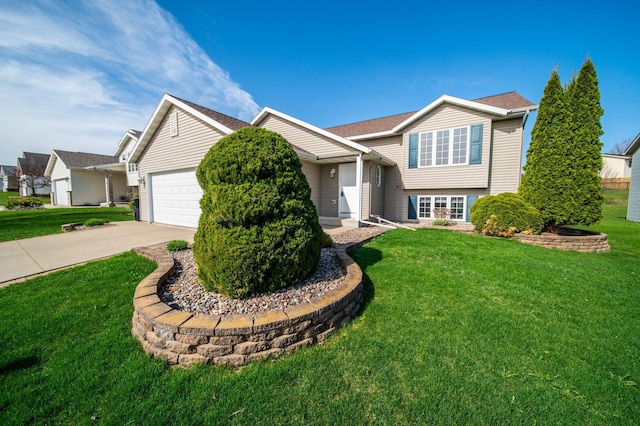 split level home featuring concrete driveway, an attached garage, and a front yard