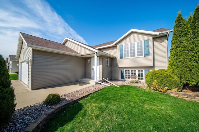 split level home with a garage, roof with shingles, driveway, and a front yard