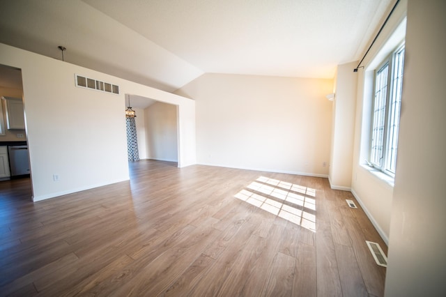 unfurnished living room with visible vents, lofted ceiling, wood finished floors, and a chandelier