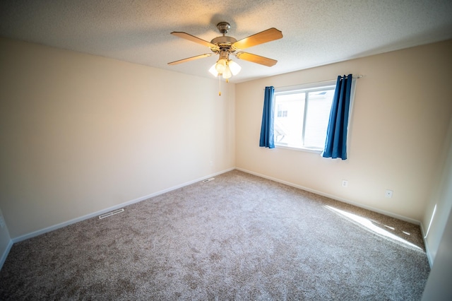 carpeted spare room with a textured ceiling, ceiling fan, and baseboards