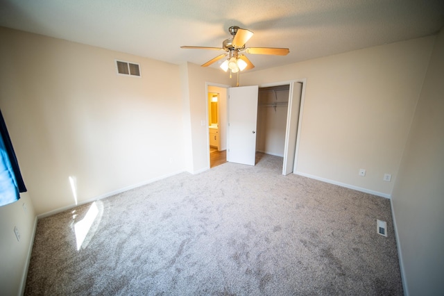 unfurnished bedroom featuring carpet floors, a ceiling fan, a closet, and visible vents