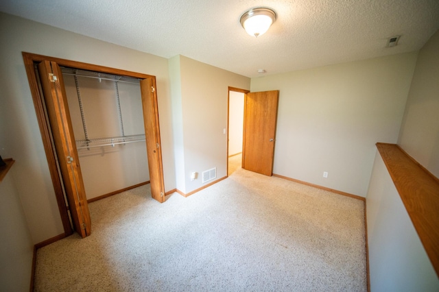 unfurnished bedroom with visible vents, carpet flooring, baseboards, and a closet