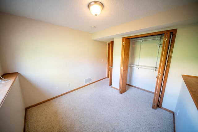 unfurnished bedroom featuring baseboards, a closet, carpet floors, and visible vents