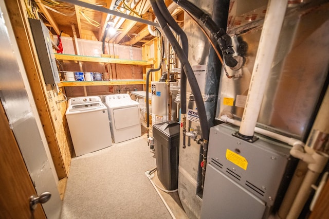 utility room with heating unit, washing machine and dryer, and gas water heater