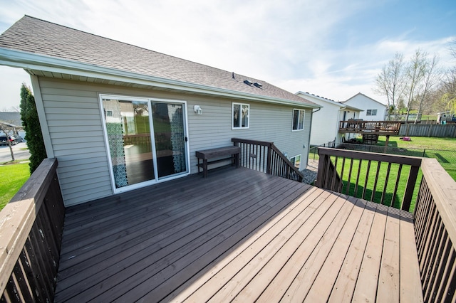 wooden deck featuring fence and a yard