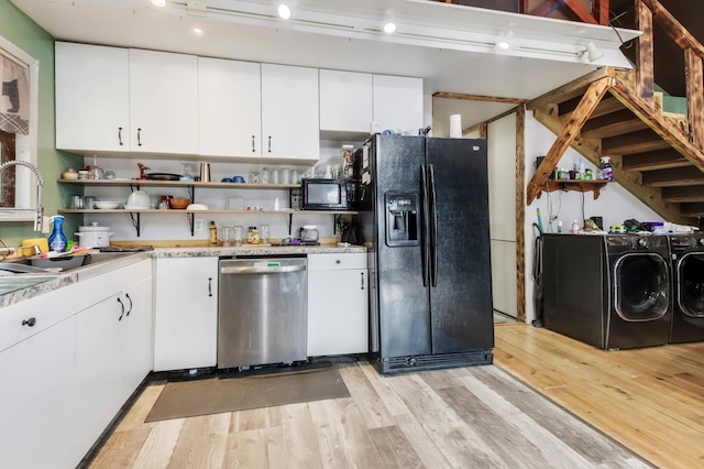 kitchen with light wood-style flooring, light countertops, open shelves, washer and clothes dryer, and black appliances