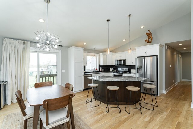 4594 Buckingham Dr NW, Rochester, MN 55901 - kitchen with appliances with stainless steel finishes, a sink, decorative backsplash, a kitchen island, and white cabinets