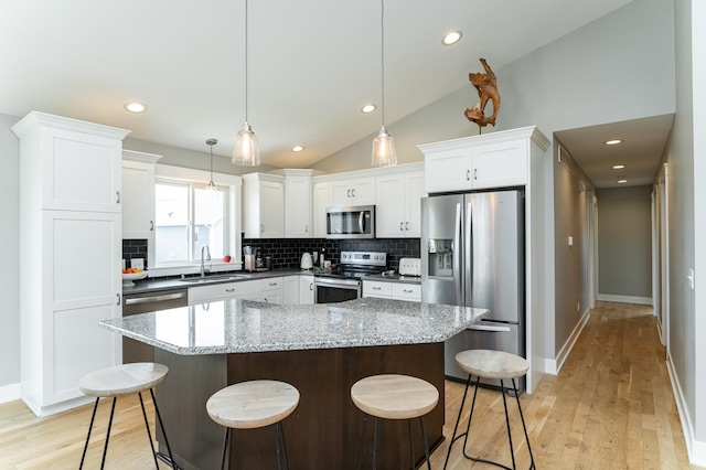 4594 Buckingham Dr NW, Rochester, MN 55901 - kitchen with appliances with stainless steel finishes, a sink, backsplash, white cabinetry, and lofted ceiling