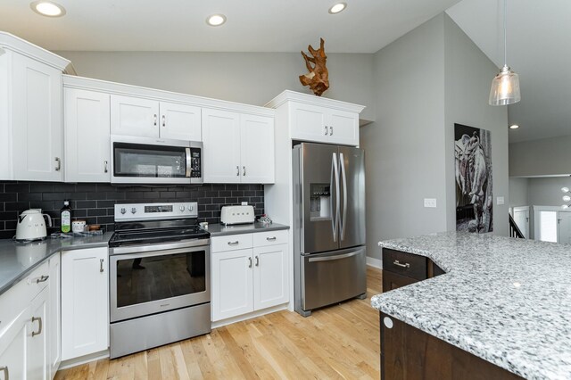 4594 Buckingham Dr NW, Rochester, MN 55901 - kitchen featuring appliances with stainless steel finishes, vaulted ceiling, decorative backsplash, white cabinetry, and light wood-style flooring