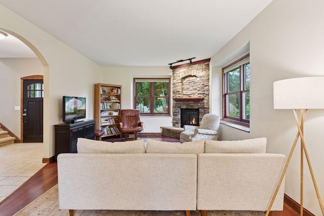 1584 Merrill St, Saint Paul, MN 55108 - living area with dark wood-type flooring, arched walkways, a fireplace, and stairs