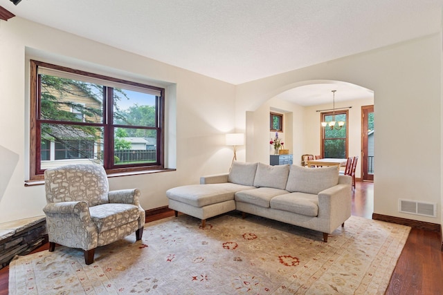 1584 Merrill St, Saint Paul, MN 55108 - living area with hardwood / wood-style flooring, arched walkways, and a chandelier