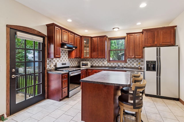 1584 Merrill St, Saint Paul, MN 55108 - kitchen with fridge with ice dispenser, stainless steel gas stove, under cabinet range hood, dark countertops, and recessed lighting