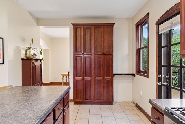 1584 Merrill St, Saint Paul, MN 55108 - kitchen with range, light tile patterned floors, dark countertops, and dark brown cabinets