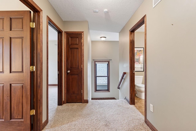 1584 Merrill St, Saint Paul, MN 55108 - hall featuring carpet floors, a textured ceiling, and an upstairs landing