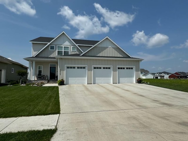 8825 Meadowlark Pkwy, Horace, ND 58047 - craftsman-style home featuring board and batten siding, a garage, covered porch, a front lawn, and driveway