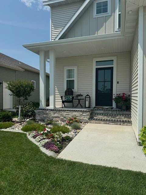 8825 Meadowlark Pkwy, Horace, ND 58047 - entrance to property with board and batten siding, a porch, and a lawn