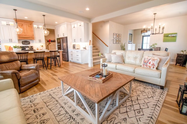 8825 Meadowlark Pkwy, Horace, ND 58047 - living area featuring light wood-style flooring, recessed lighting, stairway, a notable chandelier, and baseboards