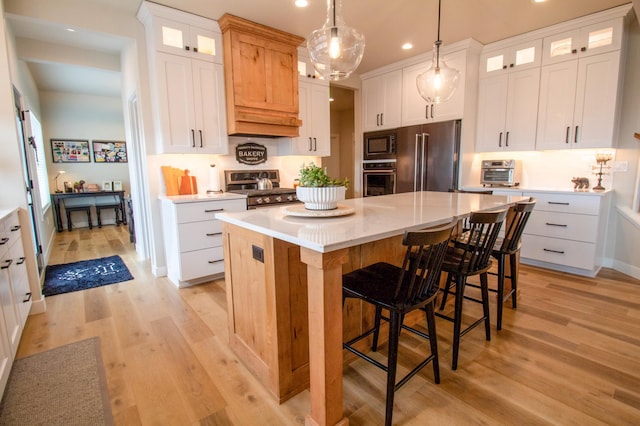 8825 Meadowlark Pkwy, Horace, ND 58047 - kitchen featuring a breakfast bar, light wood-type flooring, recessed lighting, a kitchen island, and appliances with stainless steel finishes