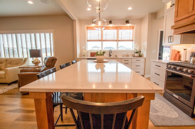 8825 Meadowlark Pkwy, Horace, ND 58047 - kitchen with a kitchen breakfast bar, recessed lighting, a center island, gas range, and a sink