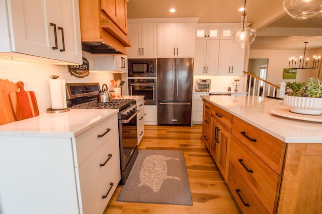 8825 Meadowlark Pkwy, Horace, ND 58047 - kitchen with pendant lighting, light wood-style floors, tasteful backsplash, white cabinets, and appliances with stainless steel finishes