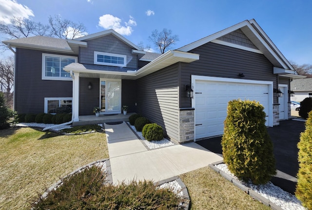 view of front of home with an attached garage, roof with shingles, covered porch, and stone siding