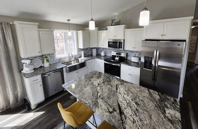 kitchen with a sink, white cabinetry, appliances with stainless steel finishes, and tasteful backsplash