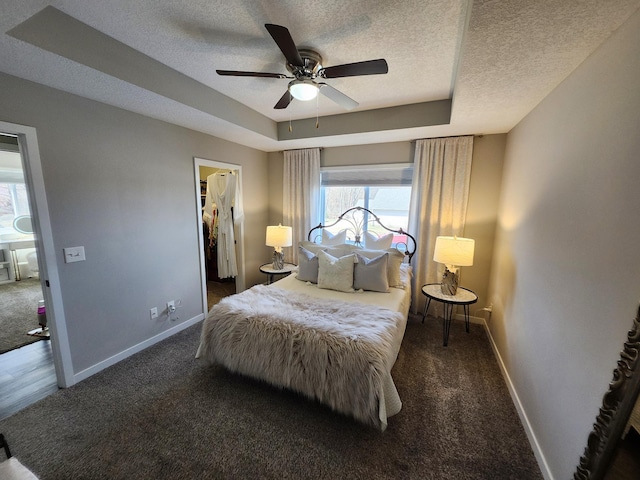 bedroom with baseboards, carpet, a textured ceiling, and a spacious closet