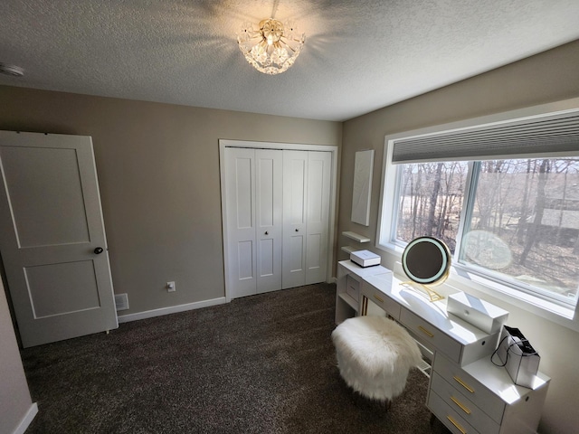 home office with dark colored carpet, a textured ceiling, and a chandelier