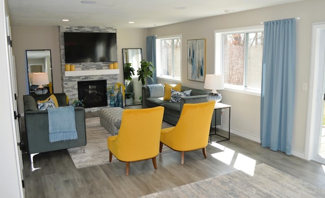 living area with recessed lighting, baseboards, wood finished floors, and a fireplace