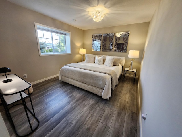 bedroom featuring baseboards, an inviting chandelier, and dark wood-style floors