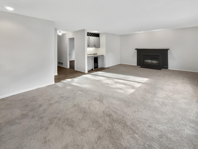 7426 Chesham Ln, Woodbury, MN 55125 - unfurnished living room featuring a fireplace with flush hearth, visible vents, baseboards, and carpet