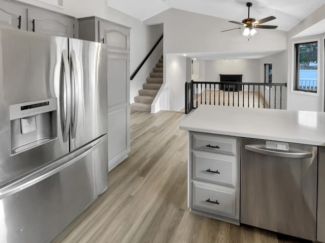 7426 Chesham Ln, Woodbury, MN 55125 - kitchen with light countertops, a ceiling fan, light wood-style floors, lofted ceiling, and appliances with stainless steel finishes