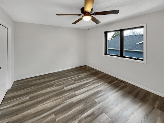 7426 Chesham Ln, Woodbury, MN 55125 - unfurnished bedroom with dark wood-type flooring, visible vents, baseboards, and ceiling fan