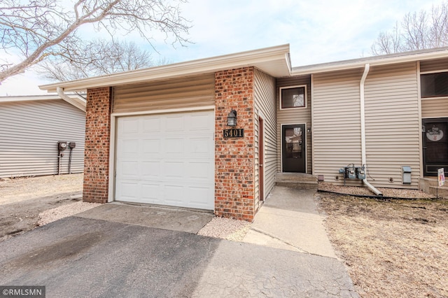5401 70th Cir N, Brooklyn Center, MN 55429 - view of front of home featuring a garage, driveway, and brick siding