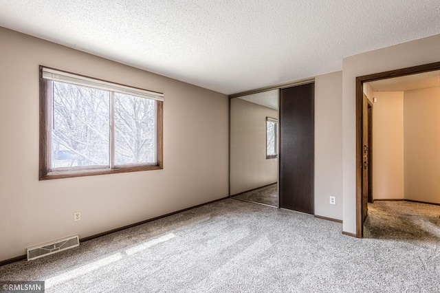 5401 70th Cir N, Brooklyn Center, MN 55429 - unfurnished bedroom featuring carpet, a textured ceiling, and a closet