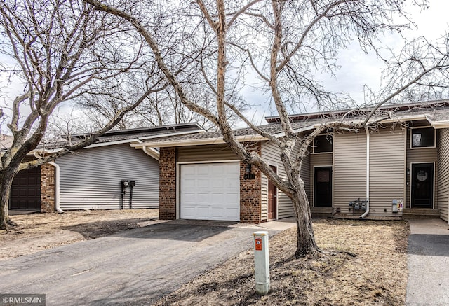5401 70th Cir N, Brooklyn Center, MN 55429 - mid-century home featuring a garage, asphalt driveway, and brick siding